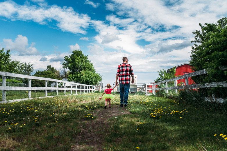 A father and daughter's day in the life, walking hand in hand on their acreage in Southern Alberta