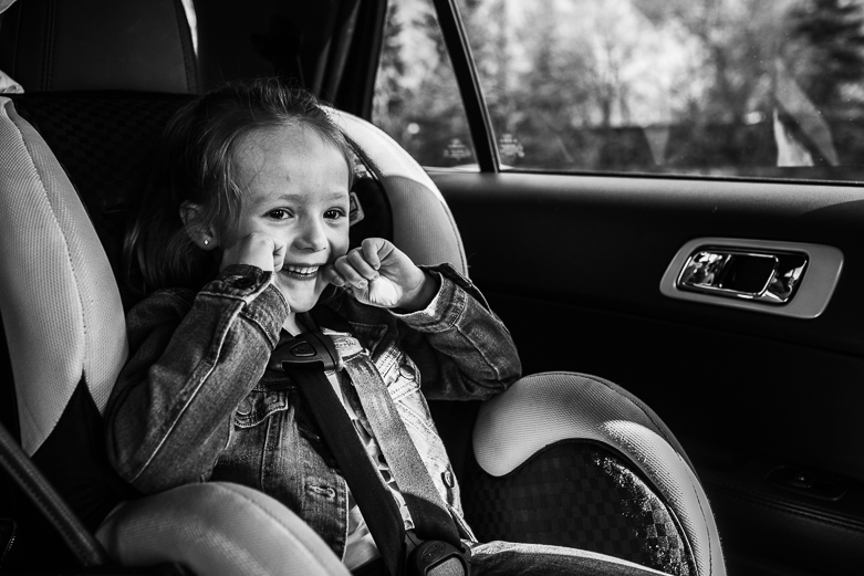 Happy girl in car seat
