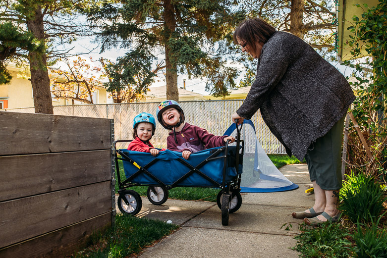 Mother pushing girls in pull wagon
