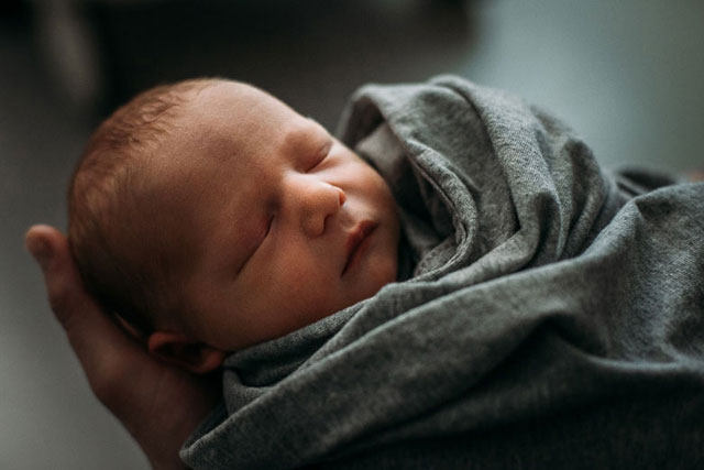 Newborn in grey wrap